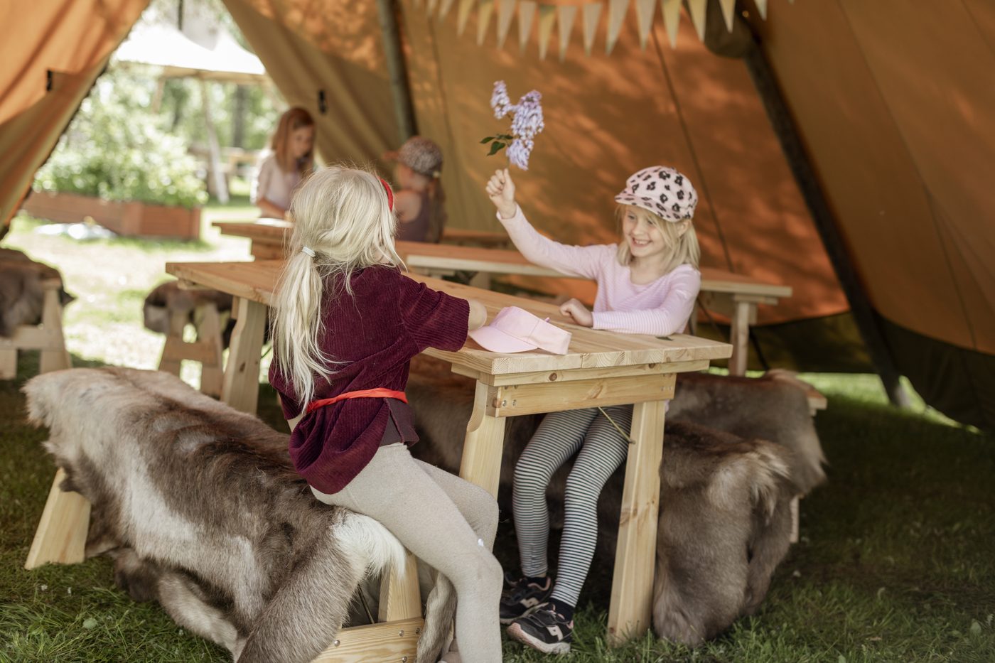 Children learning and exploring together inside outdoor tipi classroom, early years education
