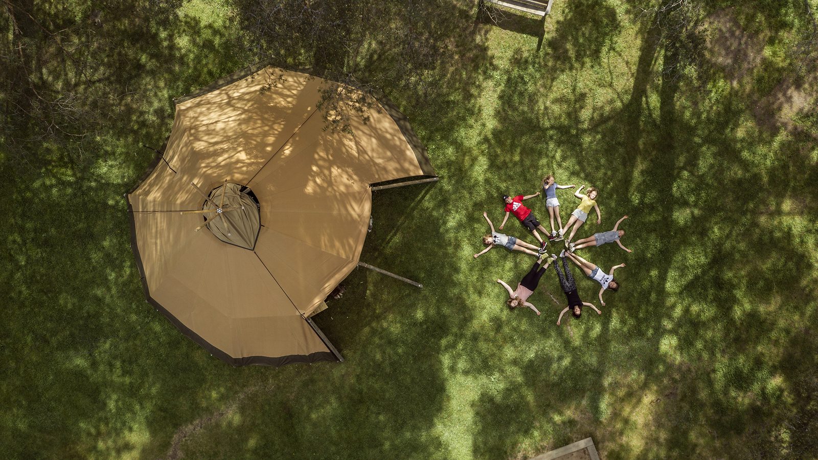 Aerial view of children learning near outdoor tipi classroom