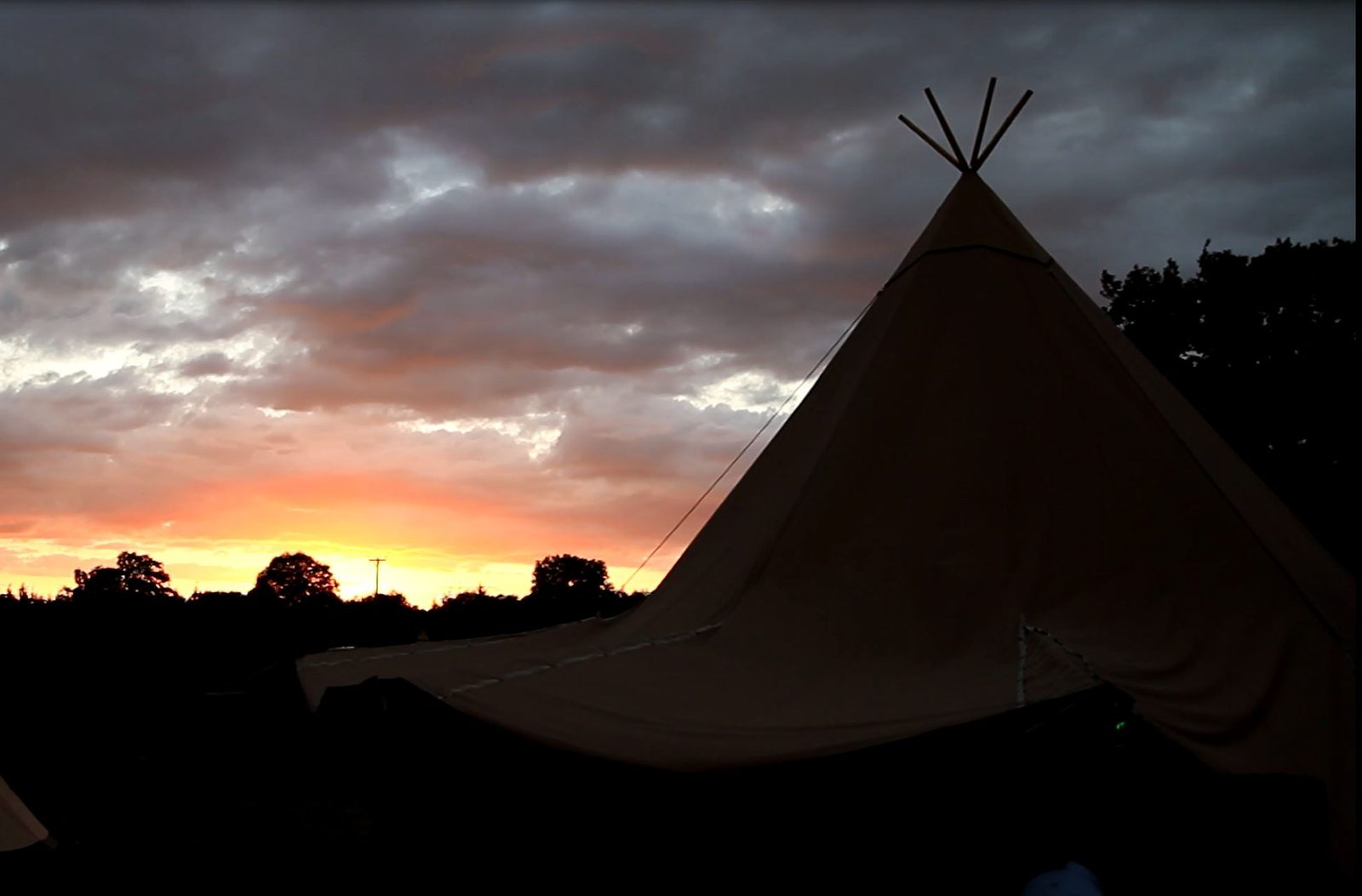 A Beehive Stratus 72 tipi silhouetted against a dramatic sunset sky — built for Scottish weather