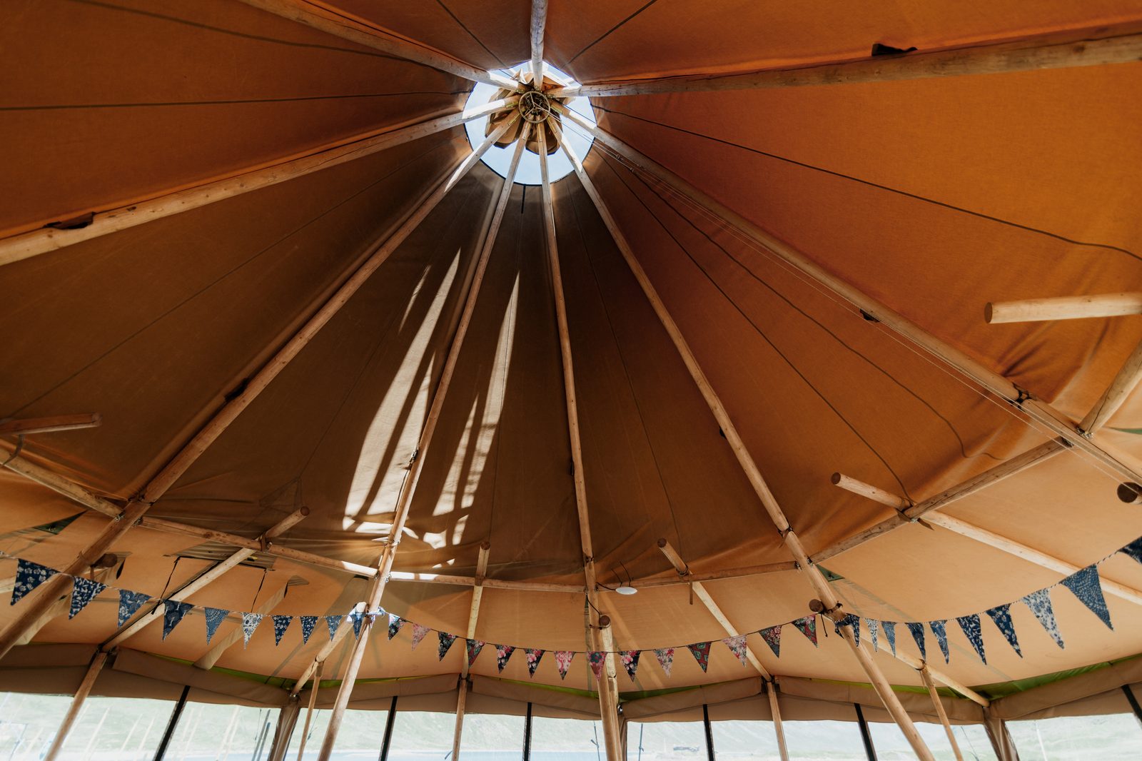 Inside a Beehive Stratus 72 tipi looking up at the smoke cap and structure — engineered for North East weather
